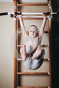 Home workout. The boy raises his legs in the hang