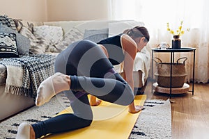 Home workout during coronavirus quarantine. Woman training using mat sport belt. Booty glutes building