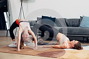 Home workout mother and daughter do bridge and gluteal bridge