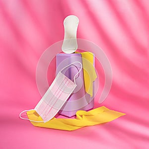 Home workout sports equipment, purple yoga block, yellow elastic bands and menstrual pad on bright pink background. The minimal