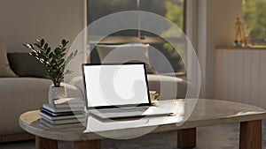 Home workspace, a white-screen laptop mockup on a marble coffee table in a comfortable living room