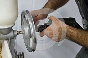 Homebrewer setting up a malt mill to grind with the aid of a dri