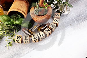 Homegrown and aromatic herbs with rosemary and basil. Wellness sign with wooden cubes