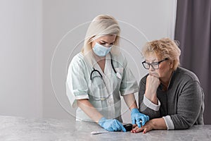 Homehealth care. Woman nurse in a medical mask help middle aged woman during during illness or pressure, female