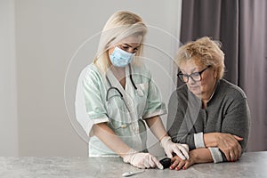 Homehealth care. Woman nurse in a medical mask help middle aged woman during during illness or pressure, female