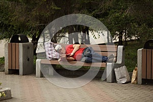 Homeless beggar lying on a bench