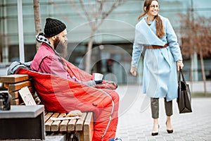 Homeless beggar with passing by business woman