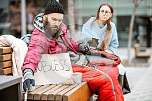 Homeless beggar with young business woman