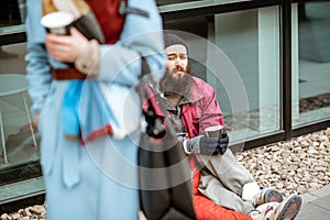 Homeless begging money to a passing by woman