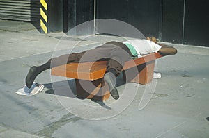 Homeless black man sleeping on a park bench, New York City, New York