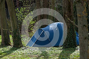 homeless in blue igloo tent in urban park