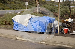 A homeless camp with blue tarp during a rain storm