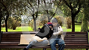 A homeless couple, a man and woman on a bench in a city Park