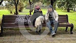 A homeless couple, a man and woman on a bench in a city Park