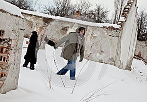 Homeless couple walking in the snow holding hands