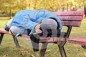 Homeless elderly woman sleeping rough in a park