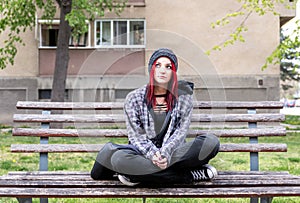 Homeless girl, Young red hair girl sitting alone outdoors with hat and shirt anxious and depressed after she became a homeless