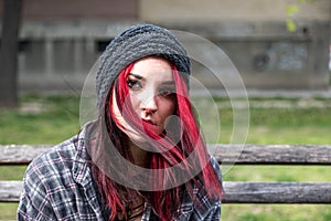 Homeless girl, Young red hair girl sitting alone outdoors with hat and shirt anxious and depressed after she became a homeless