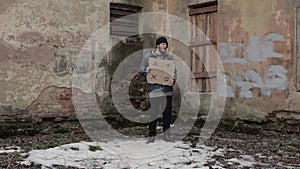 Homeless holds piece of cardboard with markers for planar tracking. Refugee looking for job. Male tramp in dirty clothes