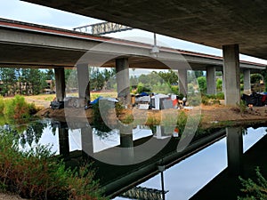 Homeless Island, with ugly encampments under highway overpass