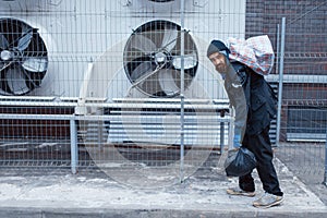 Homeless man with bag on city street