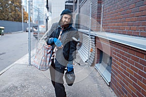 Homeless man with bag on city street