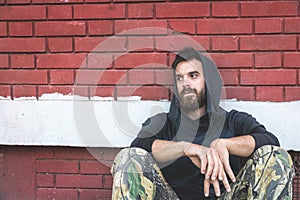 Homeless man drug and alcohol addict sitting alone and depressed on the street