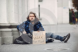 Homeless man in a durty clothes autumn city