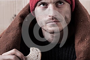 Homeless man eating a piece of bread