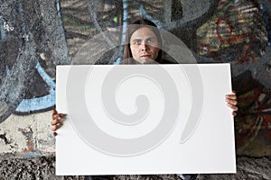 Homeless man holding a blank sign