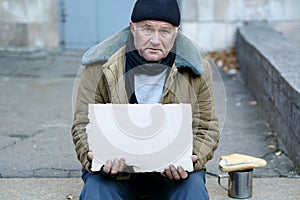 Homeless man holding a cardboard sign