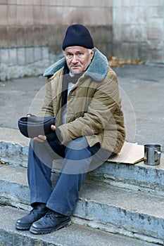 Homeless man holding his cap