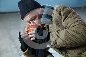 Homeless man hungrily drinking water