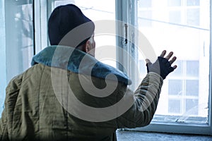 Homeless man is looking out of the window