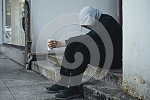 Homeless man sits on steps and asks for help and money