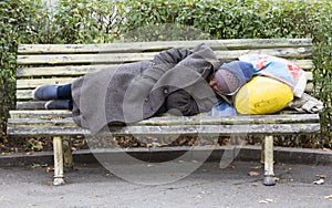 Homeless man sleeping on a bench