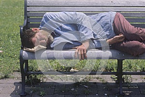 Homeless man sleeping on a park bench, Los Angeles, California