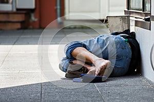 Homeless man sleeps on the street, in the shadow photo