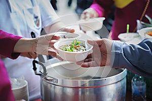 Homeless and needy people receive help, receive food from volunteers : concept of food donation