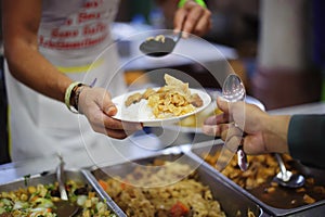 Homeless people and hungry people line up, asking for free food from volunteers