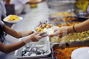 Homeless people and hungry people line up, asking for free food from volunteers