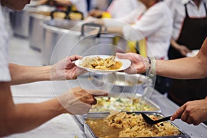 Homeless people and hungry people line up, asking for free food from volunteers