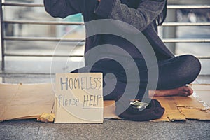 Homeless people poverty beggar man asking for money job and hoping help in helpless dirty city sitting with sign of cardboard box