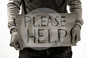 Homeless poor man holding carton board with word Please help