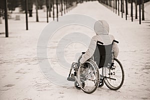 Homeless woman sits in a wheelchair in winter. black and white.