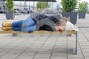 Homeless woman sleeping rough on a bench