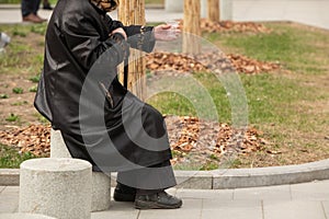 Homeless woman on the street begging with a plastic Cup in her hand