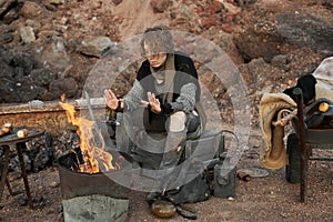 Homeless woman warming up near the fire