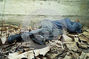 Homeless wore a gray hat and gray long-sleeve shirt. Is sleeping because of exhaustion, with the back leaning against the Siemens