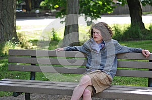 Homeless youth sits on bench